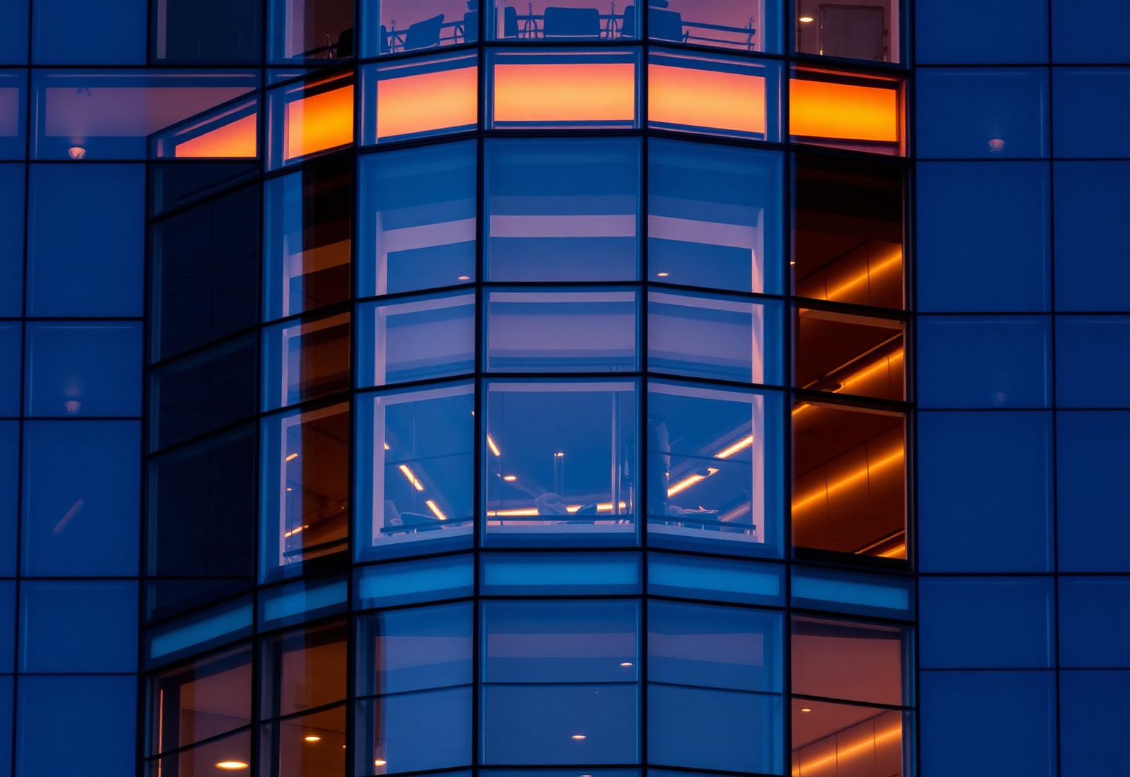 Curved corporate glass facade reflecting dusk light